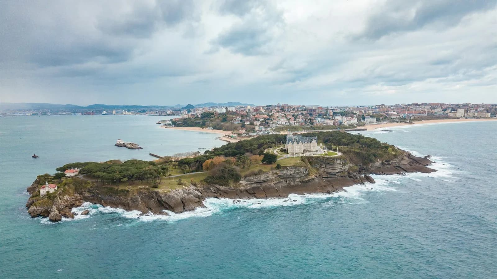 Vista aérea de la península y el Palacio de la Magdalena en Santander, con la ciudad y la playa del Sardinero al fondo